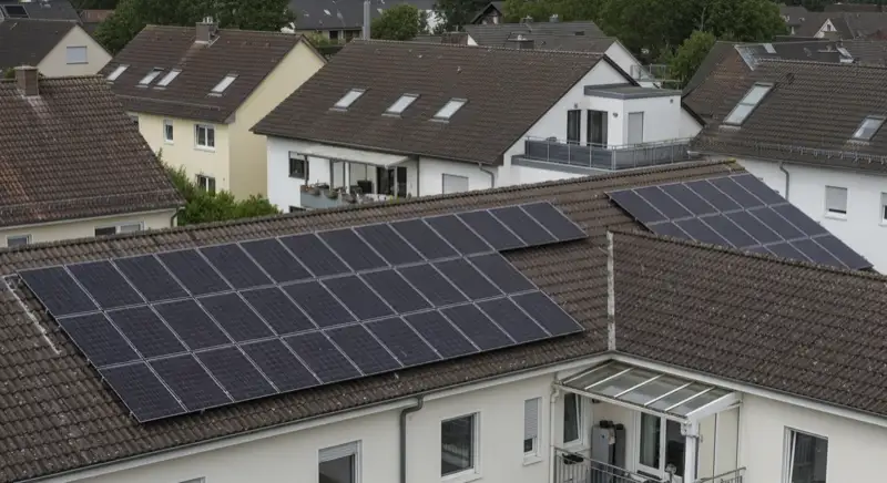 Installateur bei der Wartung einer Photovoltaik-Anlage auf einem Dach in Dinslaken