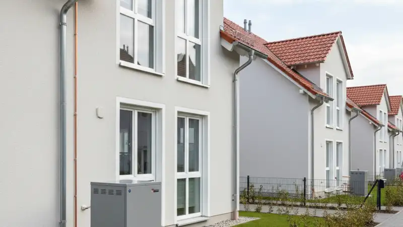 Energieberater mit Kostenaufstellung für Wärmepumpen in Jena, Laptop und Dokumente auf dem Schreibtisch